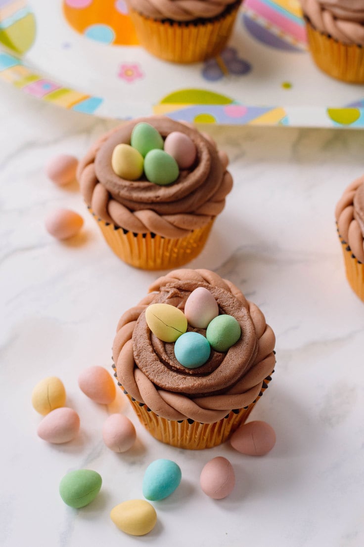 A delicious batch of chocolate cupcakes adorned with a generous amount of mini candy eggs.