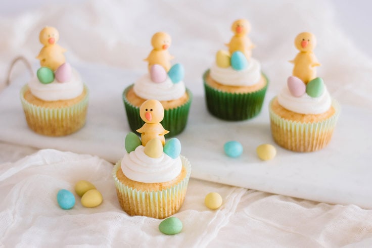 A cupcake with an easter chick made of fondant and candy eggs for the cutest Easter dessert.
