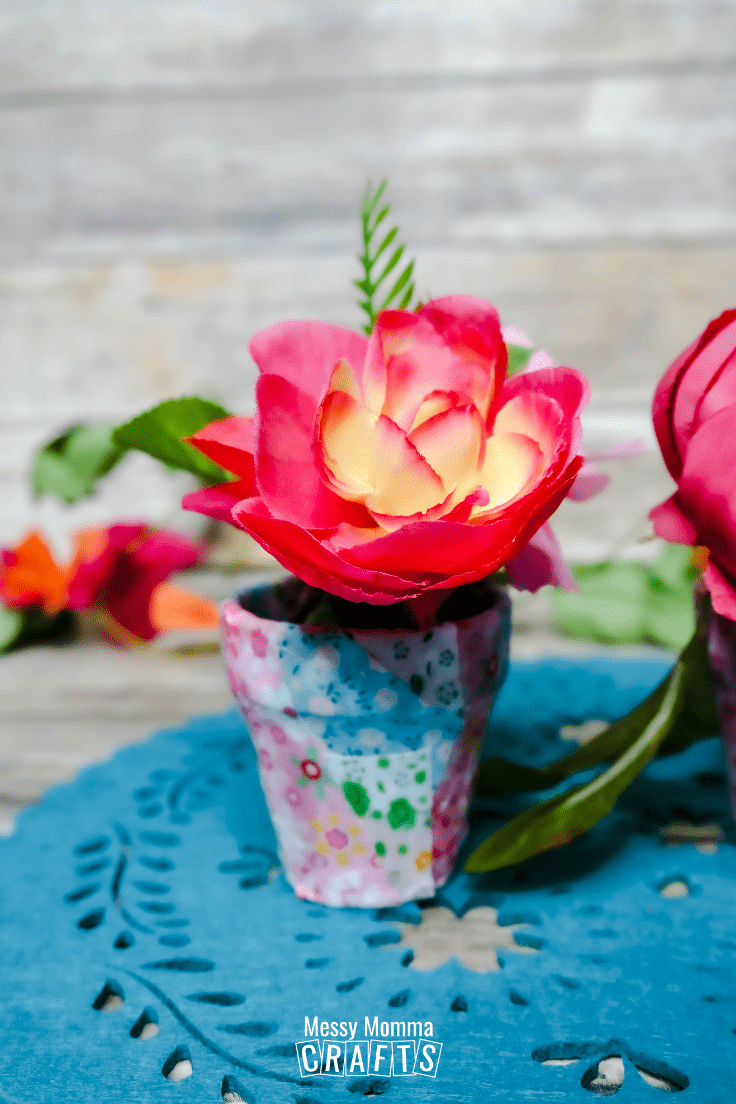Bright pink silk flowers in a DIY fabric pot.