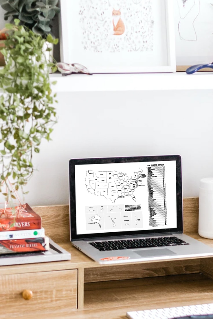 View of United States map printable on laptop screen on desk with stack of books, plant and keyboard in view.
