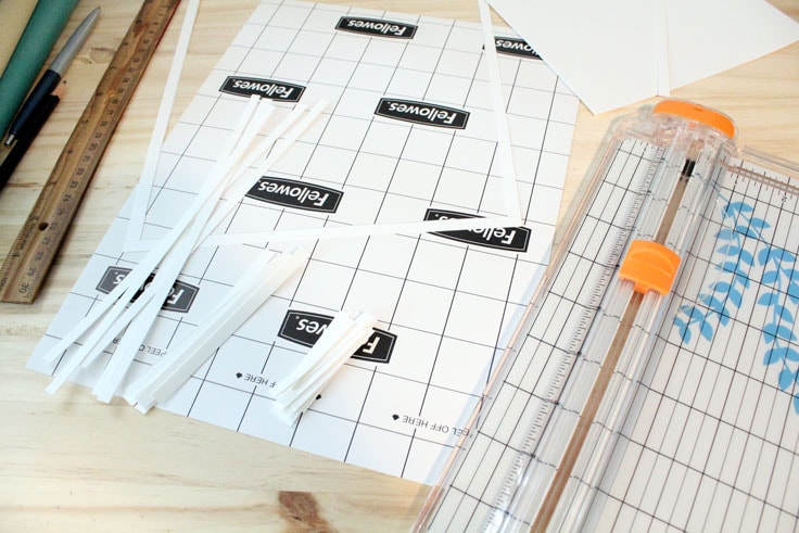 Using a paper trimmer to cut out card stock strips and a frame.