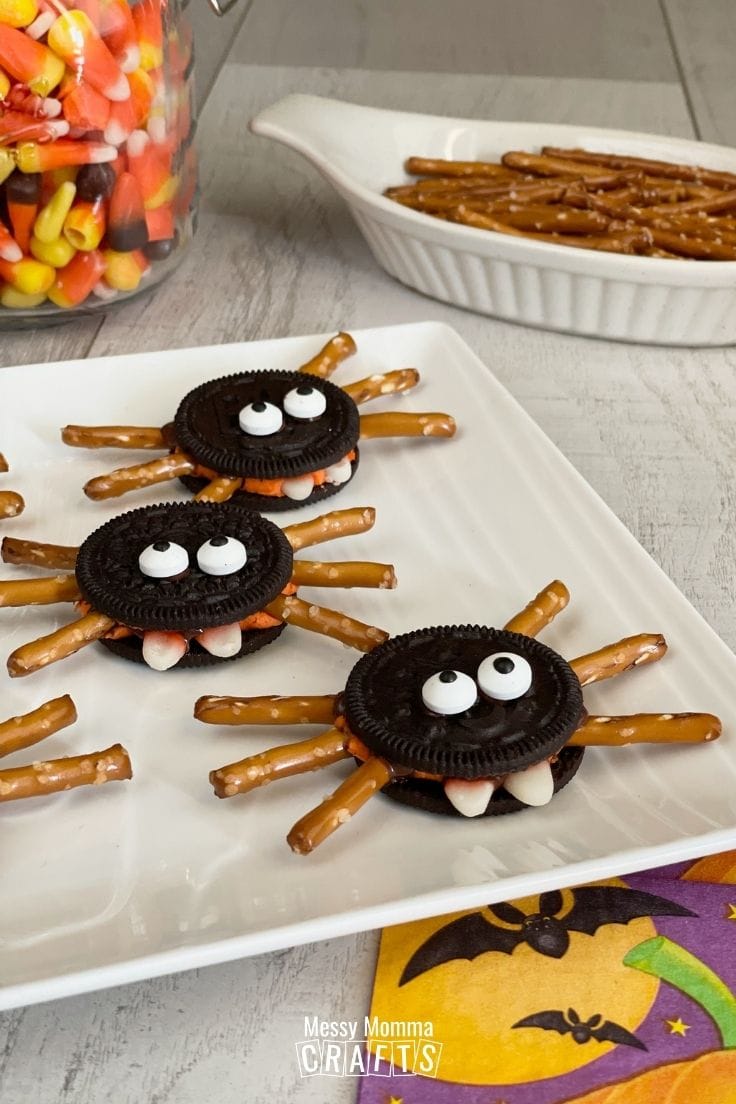 OREO Spider Cookies Spooky Halloween Treats on a white plate with Candy Corn in the background.