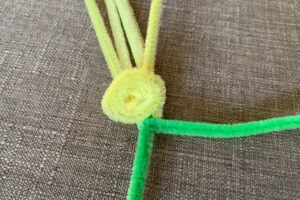 Rolling a yellow pipe cleaner into a spiral flower petal.