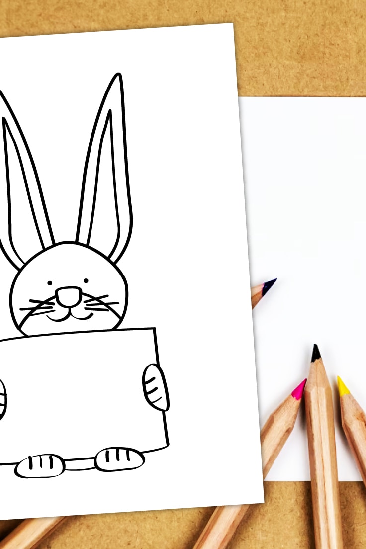 Preview of rabbit holding sign coloring page printable on cork desk with white papers and colored pencils.