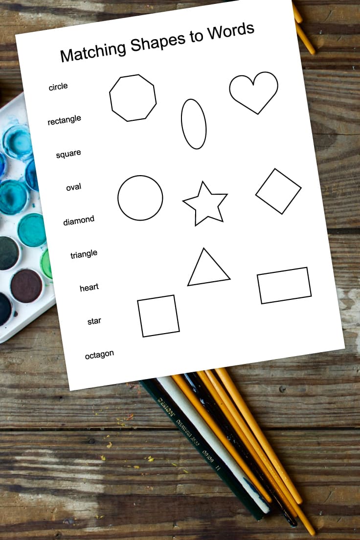 Preview of matching shapes to words kindergarten worksheet printable on top of wooden table with watercolor paint palette and brushes.