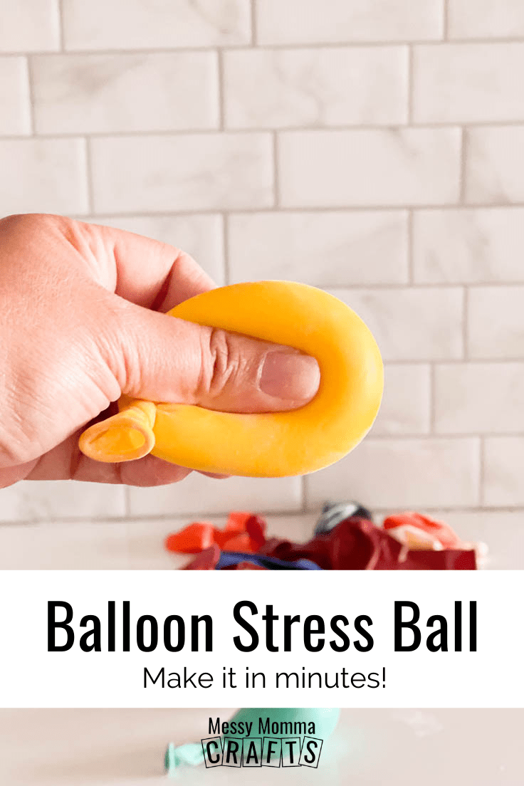 A hand pressing into a homemade yellow balloon stress ball 
