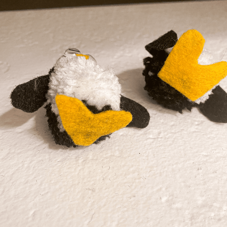 the bottoms of two pom pom penguins to show how the feet look