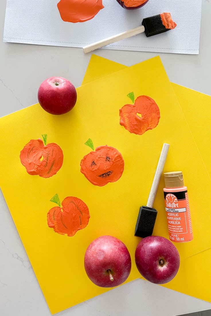 A Jack-o-Lantern design on a piece of yellow cardstock using DIY apple stamps