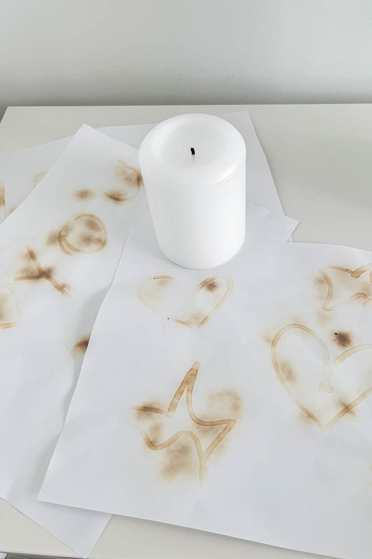 Invisible ink revealed on white paper through the open flame of a candle