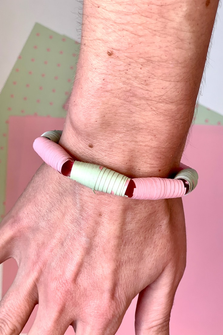 An arm wearing a paper beaded bracelet.