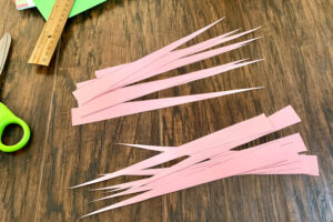 Pink p aper cut into long narrow triangular strips.