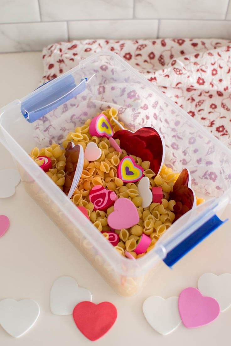 Adding heart-shaped notebooks into a plastic bin