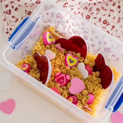 Adding heart-shaped notebooks and erasers into a plastic bin
