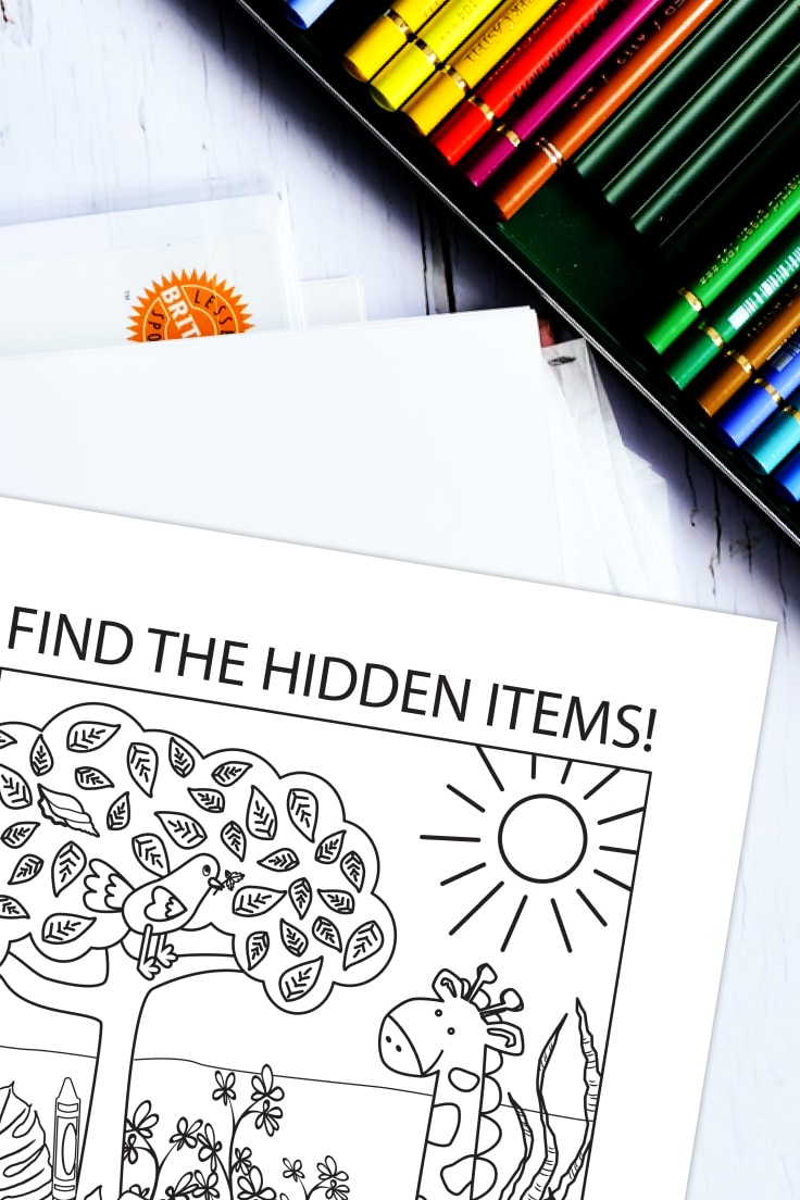 Preview of hidden pictures PDF printable with giraffe in landscape illustration and 5 hidden pictures to find, on top of white wooden desk background with colored pencils in upper right corner and papers underneath. 