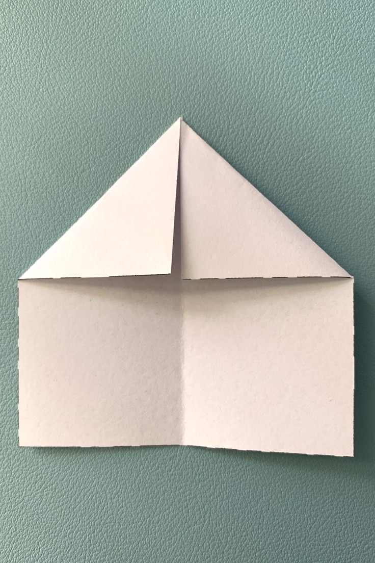 Paper folded with top 2 corners into a triangle.