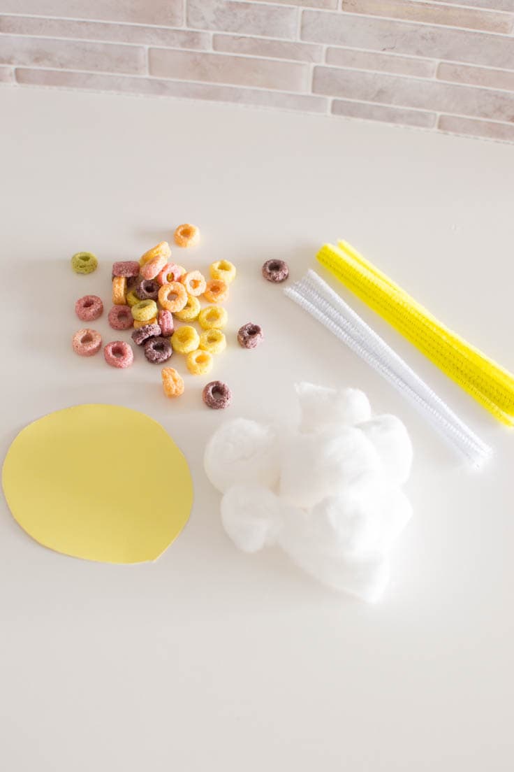 Supplies laid out on a white table required to make a Weather Sensory Bin for little ones