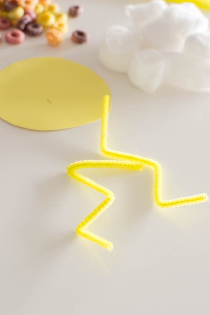 Bent yellow pipe cleaners for a DIY sensory bin