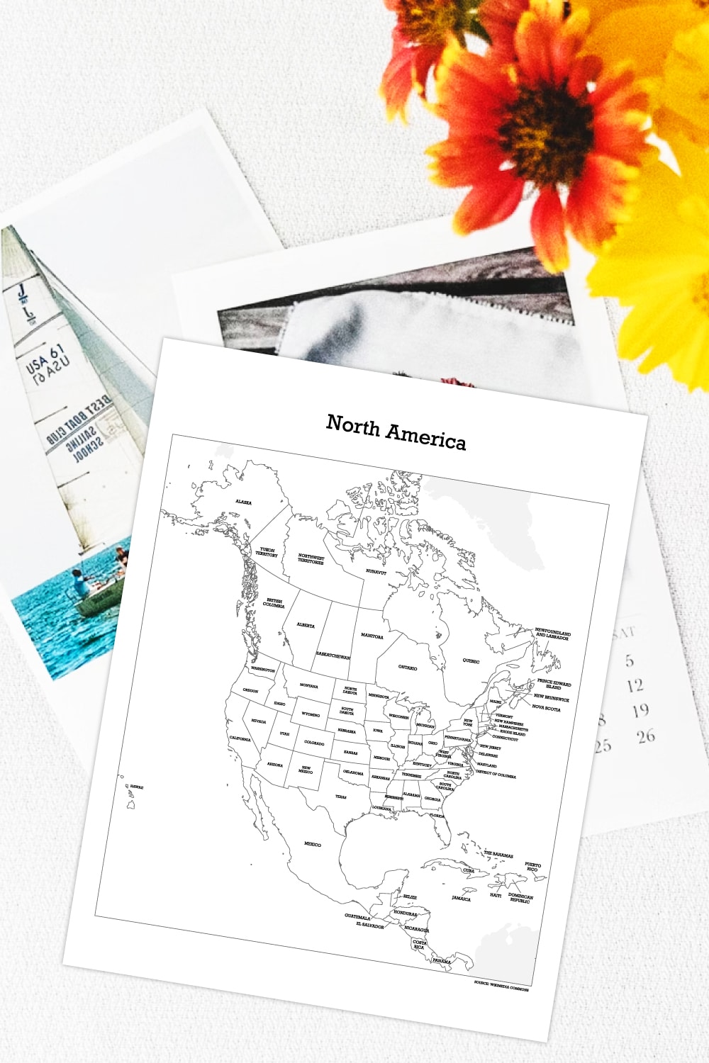 Preview of labelled North American map printable page on top of white desk with calendar pages and yellow flowers in upper right hand corner. 