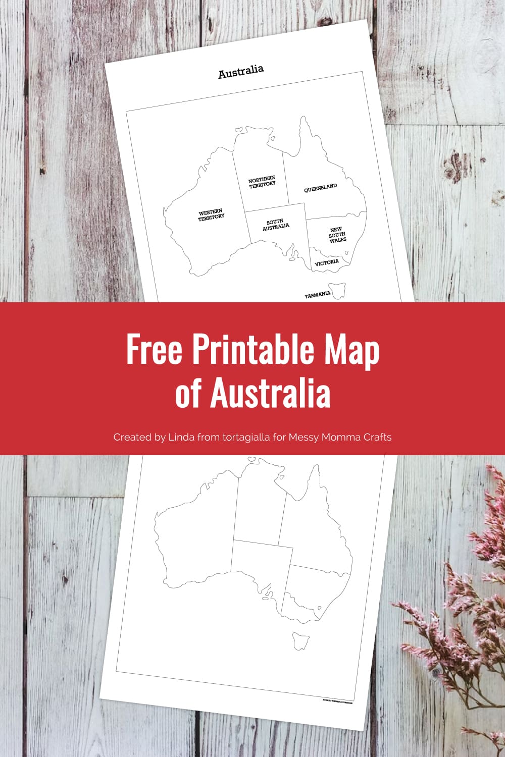 Preview of map of Australia printable pages on top of wooden plank background with some pink foliage in bottom right corner.