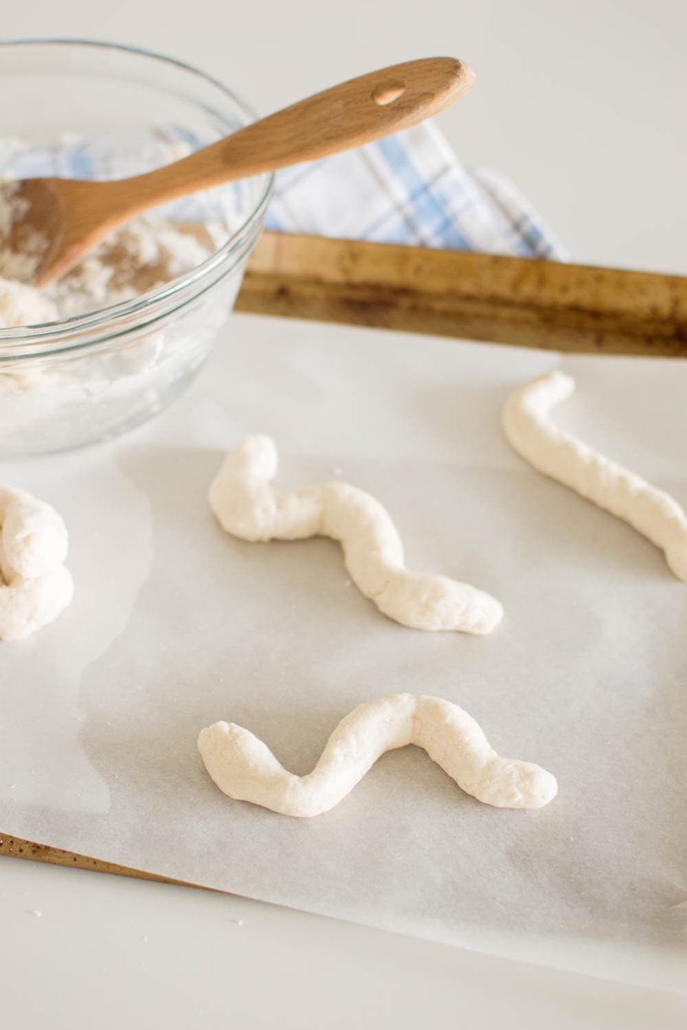 Shaping salt dough to make them look like snakes