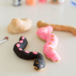 Salt dough snakes, some painted and other two sit in the background ready to be painted