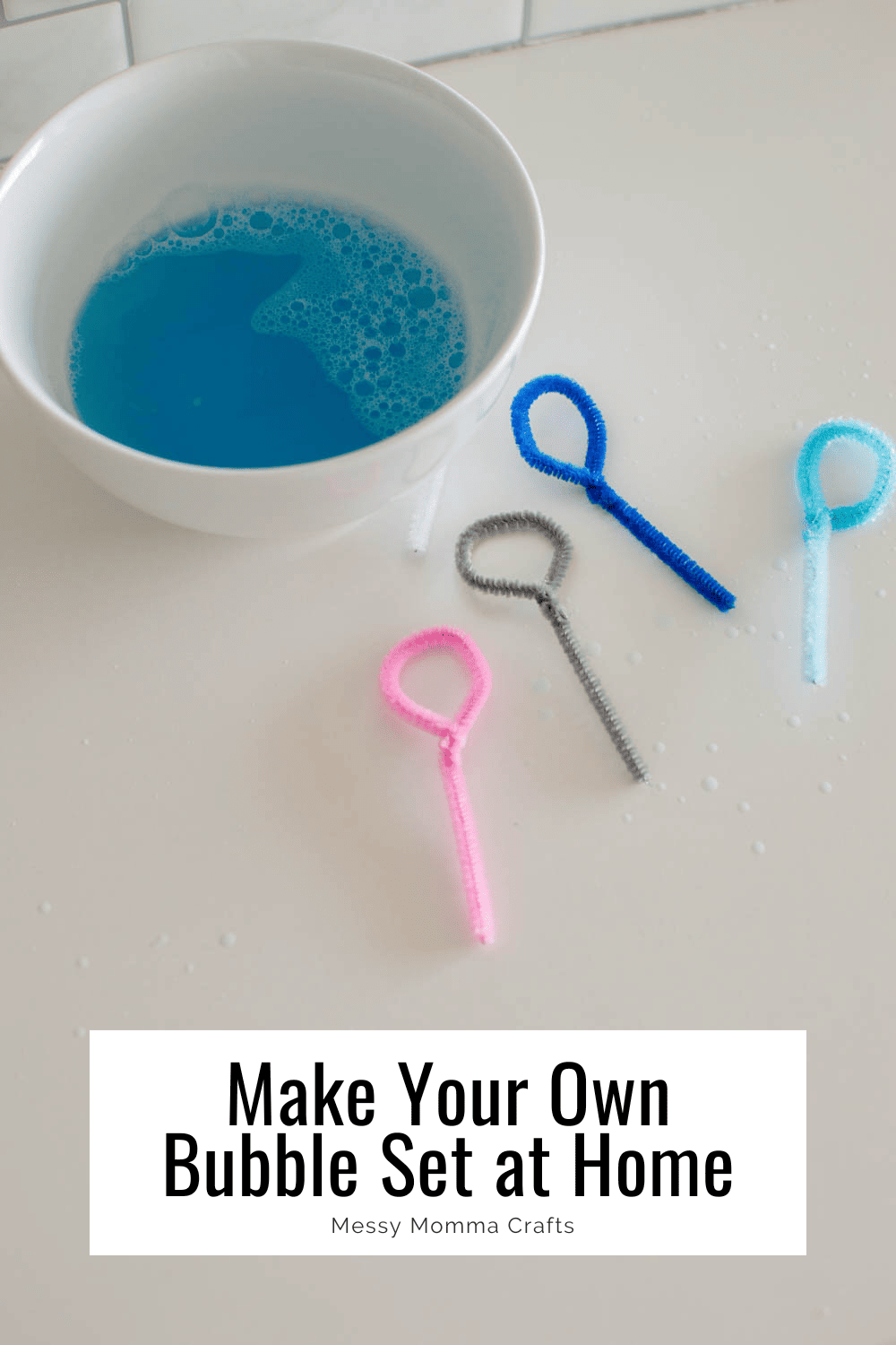 Homemade pipe cleaner bubble wands and a bowl of blue bubble solution.