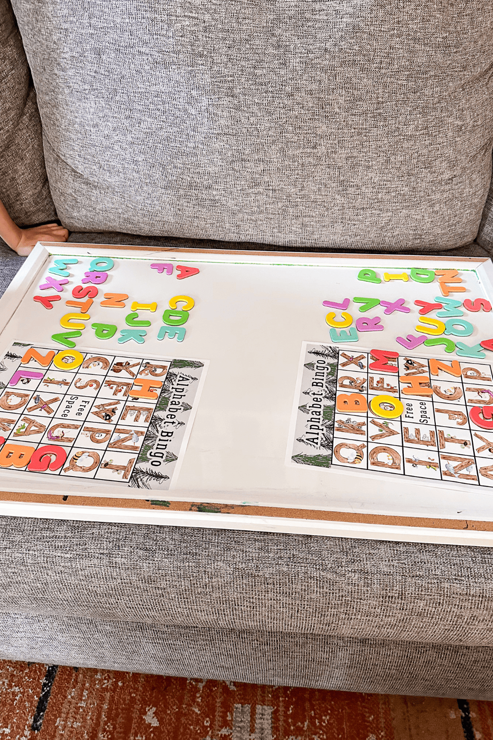 A white board with 2 Alphabet Magnet Match Bingo cards on them. A game being played