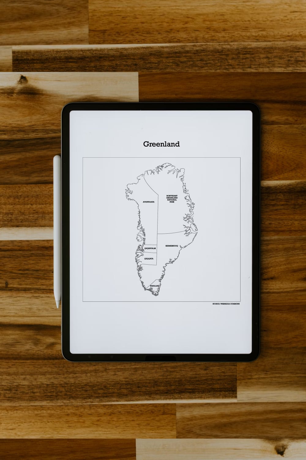 Preview of printable map of Greenland file on ipad screen on wooden desk.