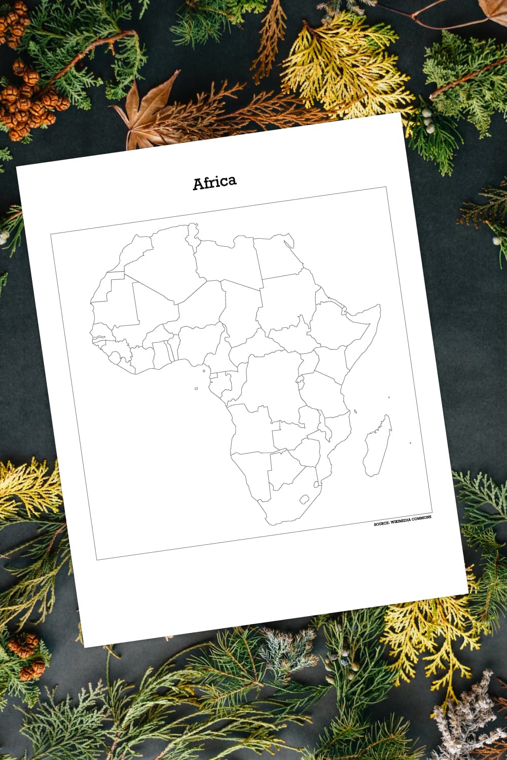 Preview of printable map of Africa on top of dark background with evergreen foilage all around border. 