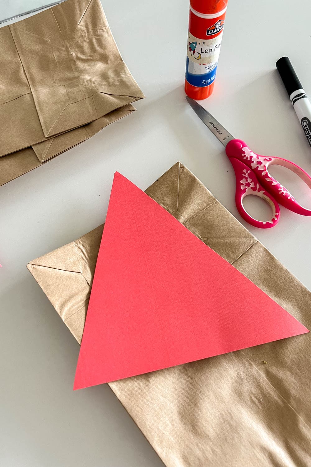 Cutting out a cardstock triangle for the paper bag scare crow's hat