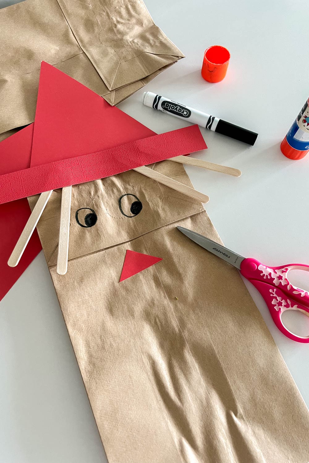Adding a cardstock nose on our paper bag DIY to make it look like a scare crow
