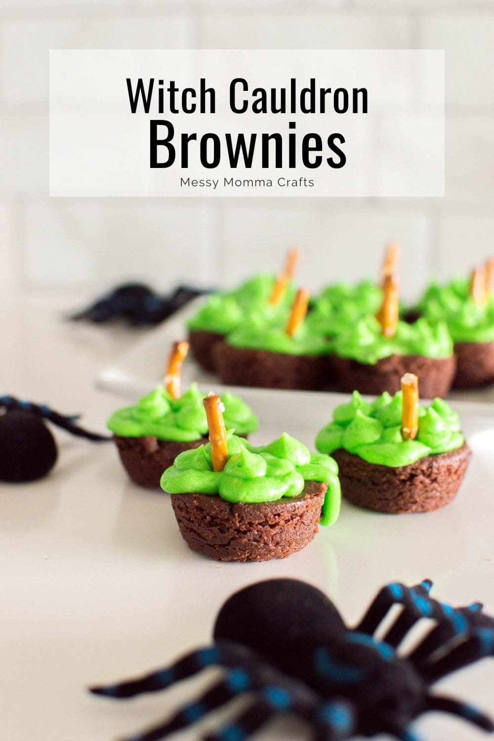 Witch cauldron brownies with green frosting and a pretzel stir stick.