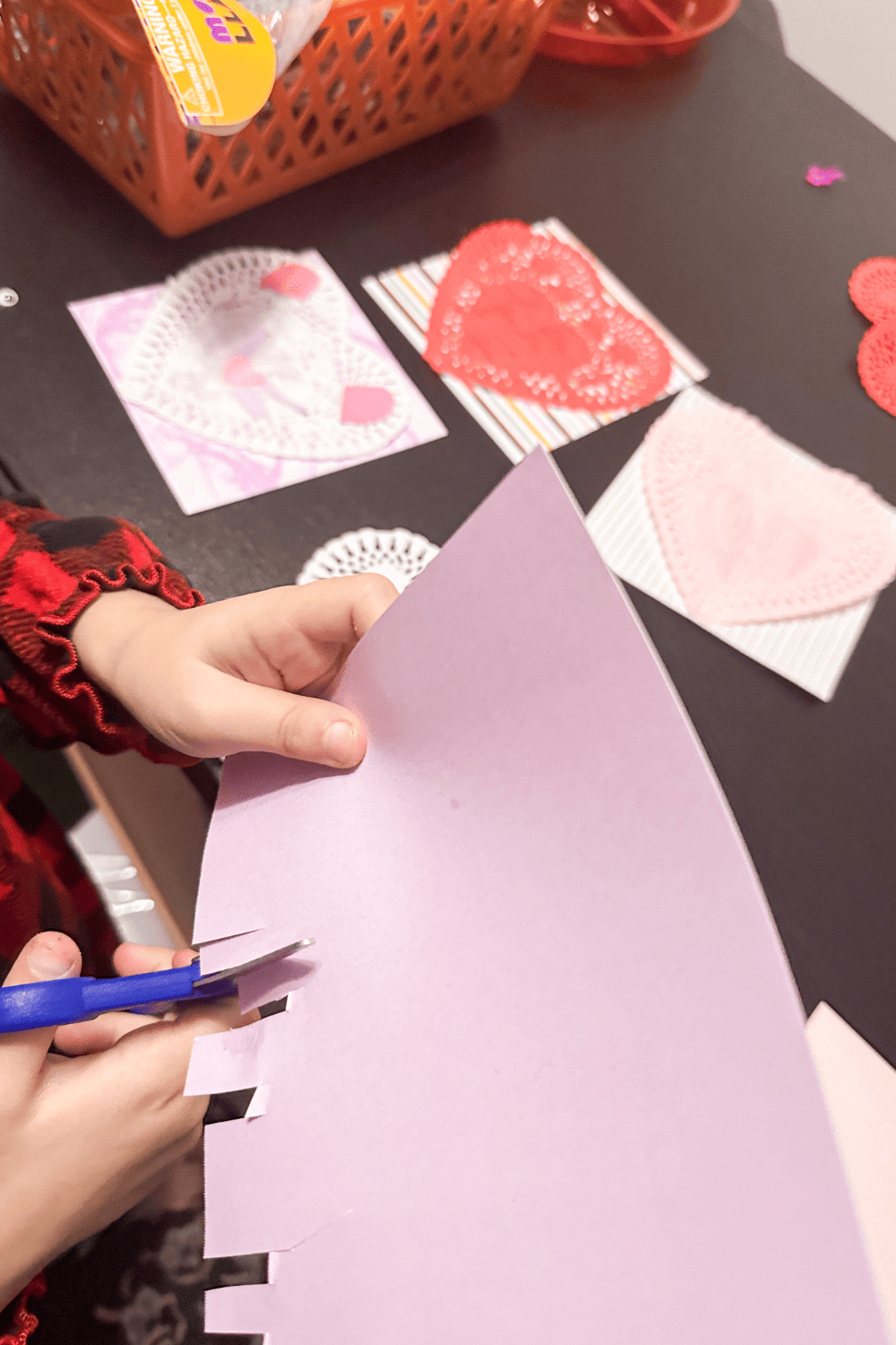 child cutting a purple paper into strips