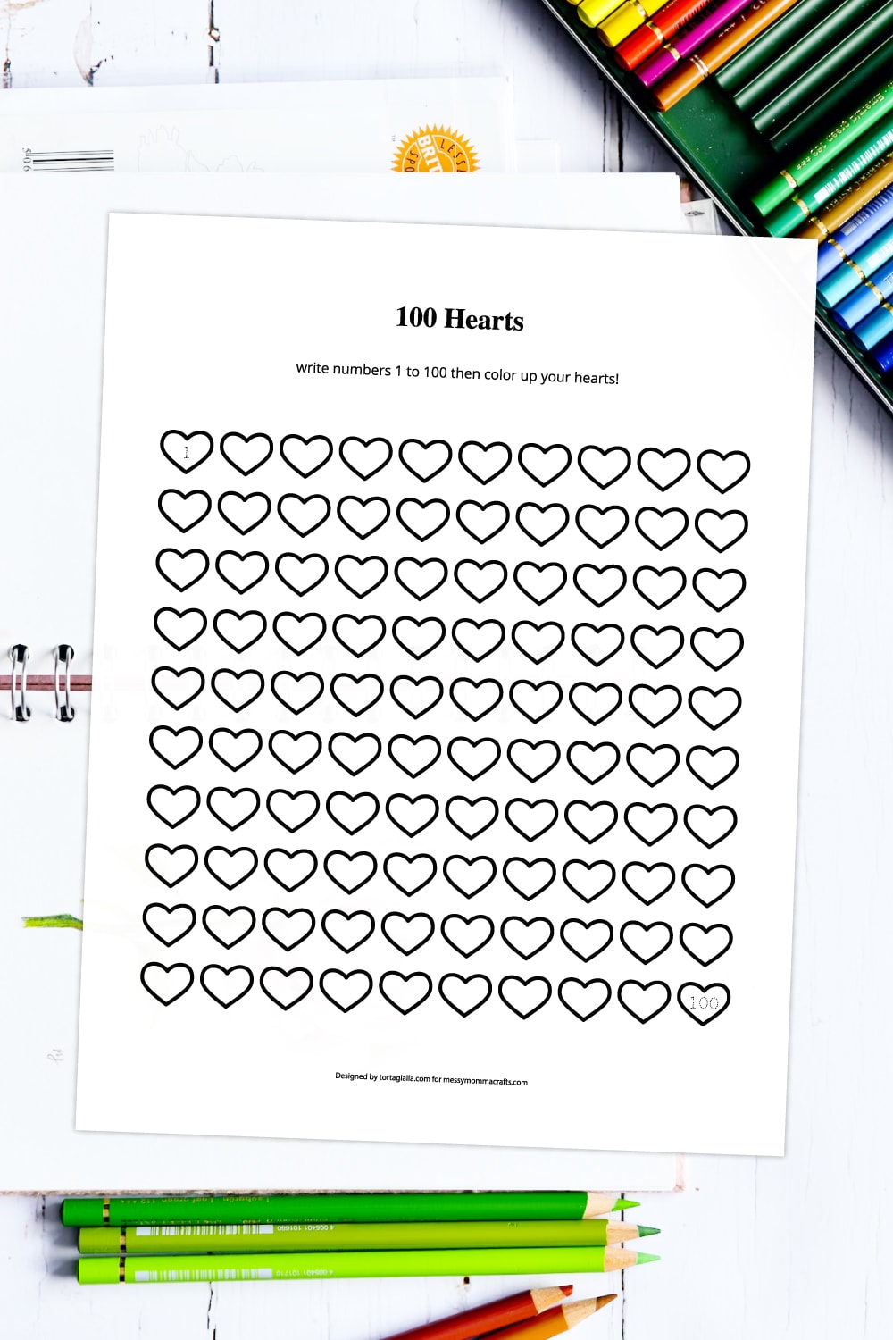 Preview of 100 hearts counting and coloring page printable worksheet on a white background with colored pencils in upper right hand corner and bottom border with spiral notebook underneath.