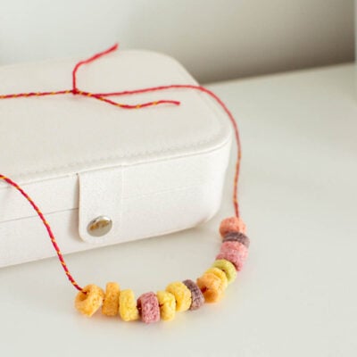 A DIY Froot Loops necklace sitting on a jewelry box